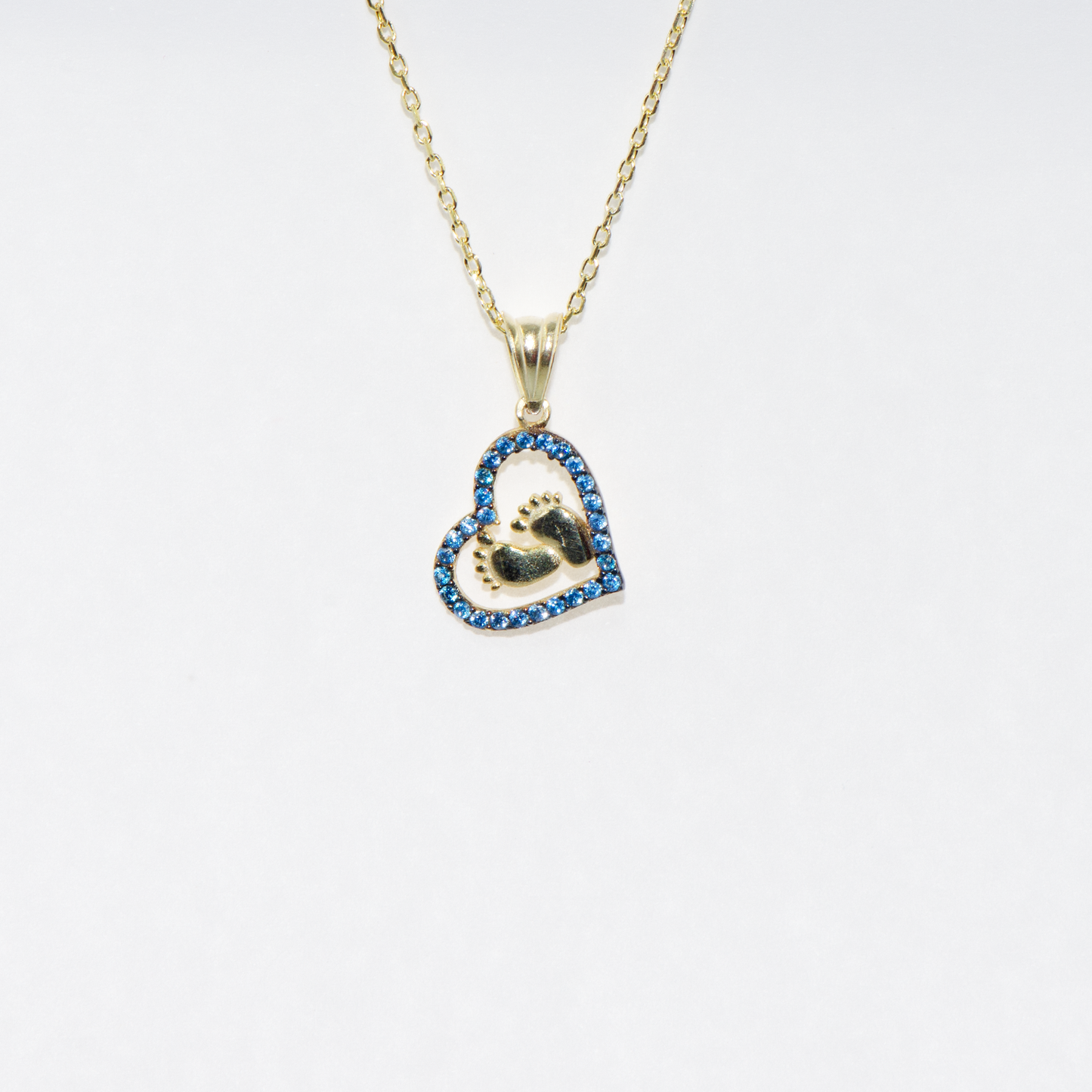 Vergoldete 925 Silber Halskette mit Herz Anhänger und Babyfüssen. Verziert mit funkelnden blauen Zirkonia-Steinen als Symbol für Liebe, Familie und besondere Erinnerungen.