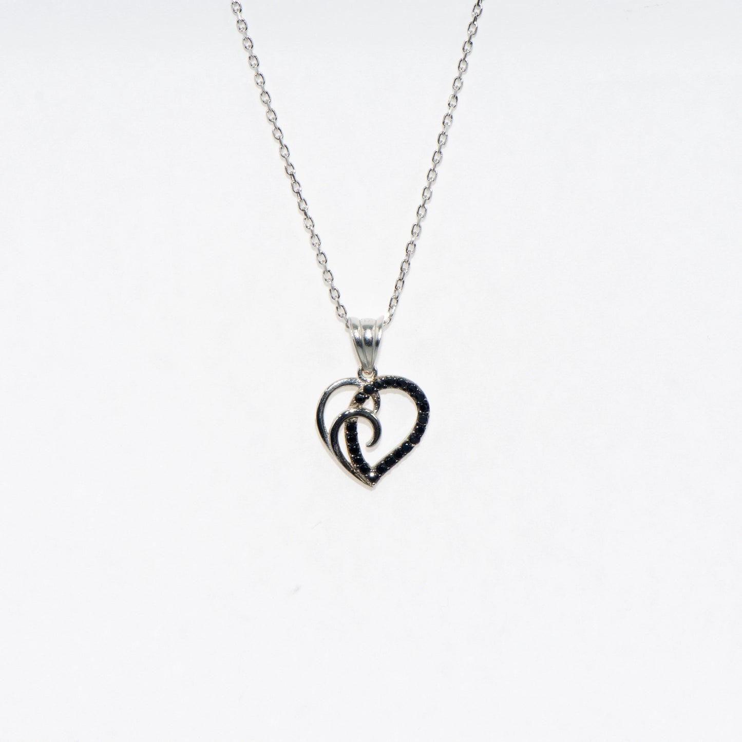 Elegante 925 Silber Halskette mit Herz Anhänger. Verziert mit schwarzen Zirkonia-Steinen und rhodinierter Oberfläche.