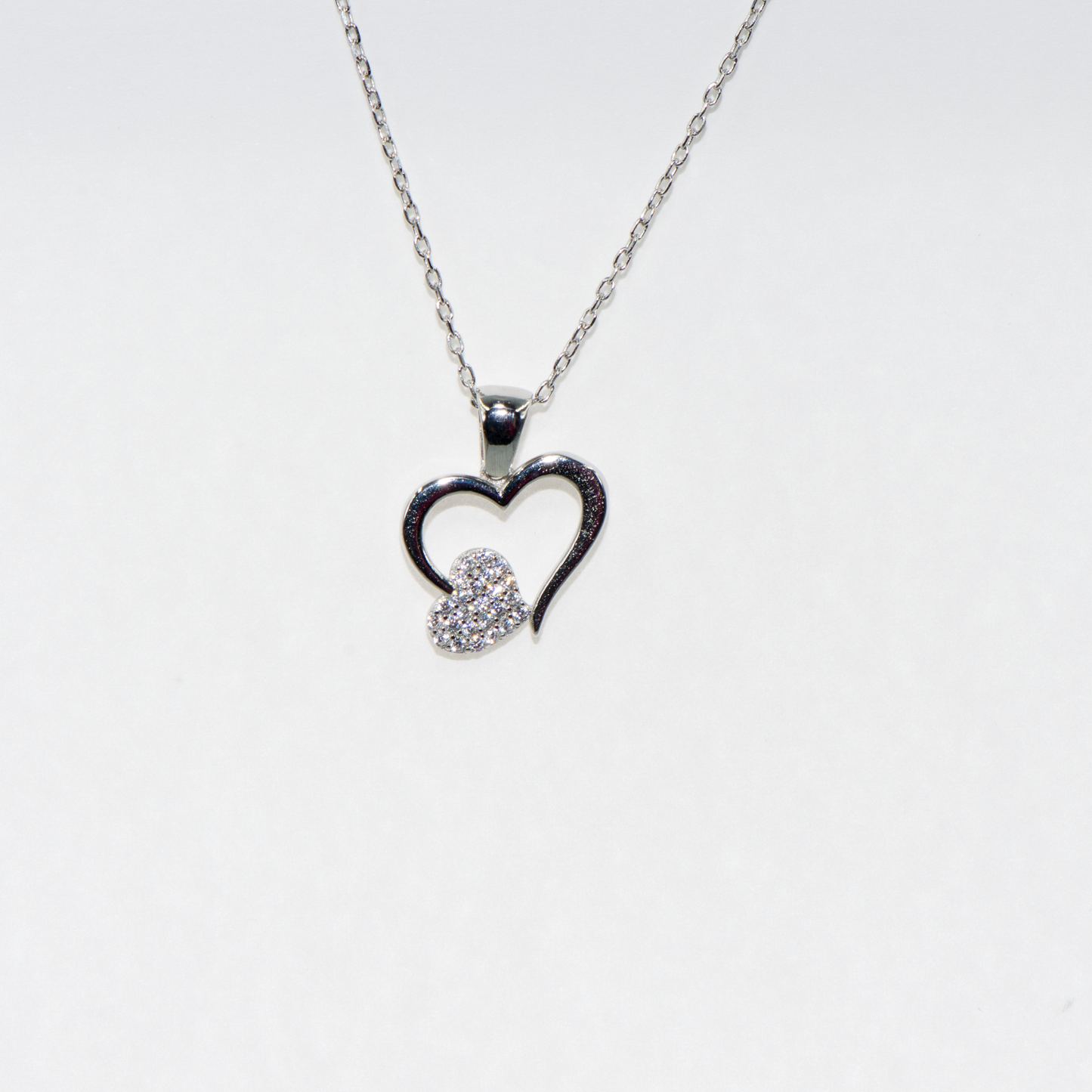 Elegante 925 Silber Halskette mit Herz Anhänger. Verziert mit funkelnden weissen Zirkonia-Steinen und rhodinierter Oberfläche.