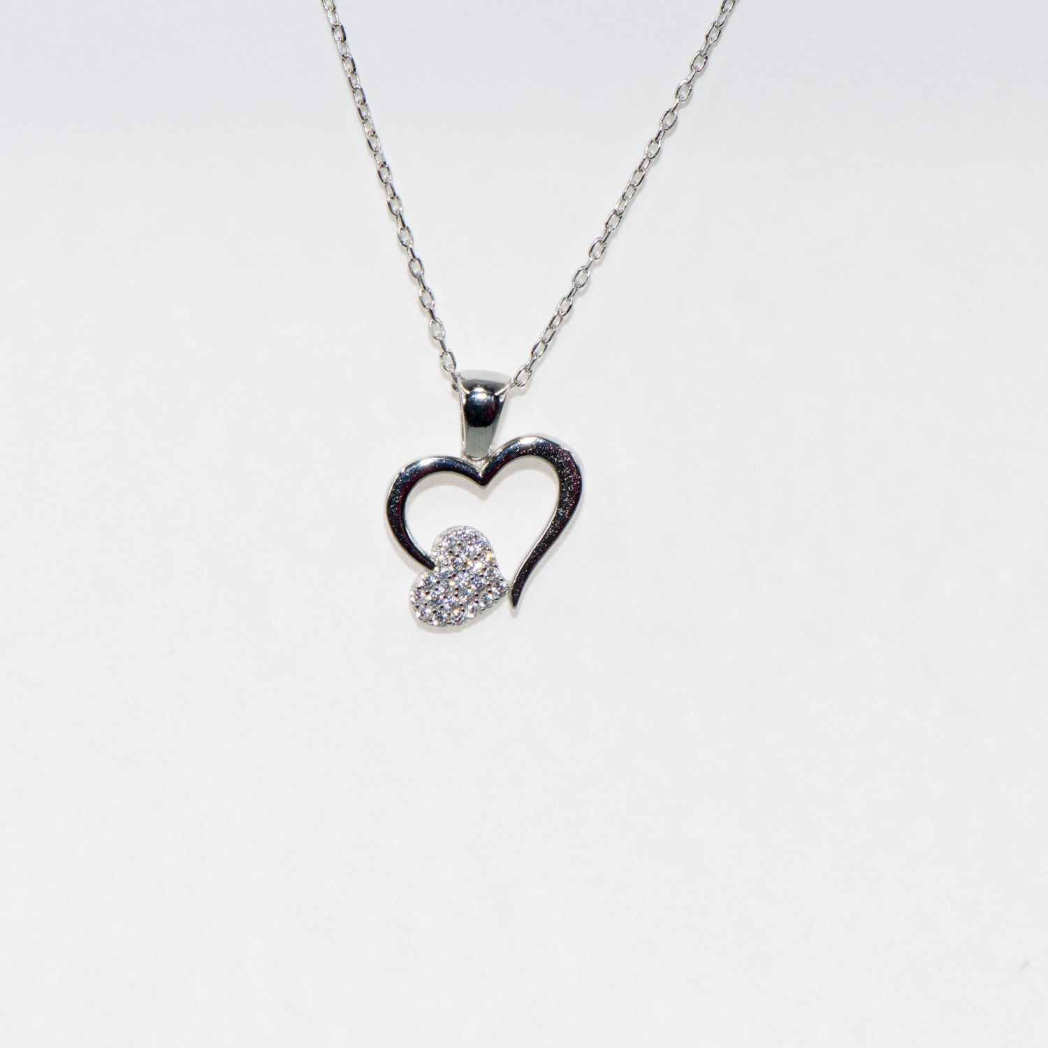 Elegante 925 Silber Halskette mit Herz Anhänger. Verziert mit funkelnden weissen Zirkonia-Steinen und rhodinierter Oberfläche.