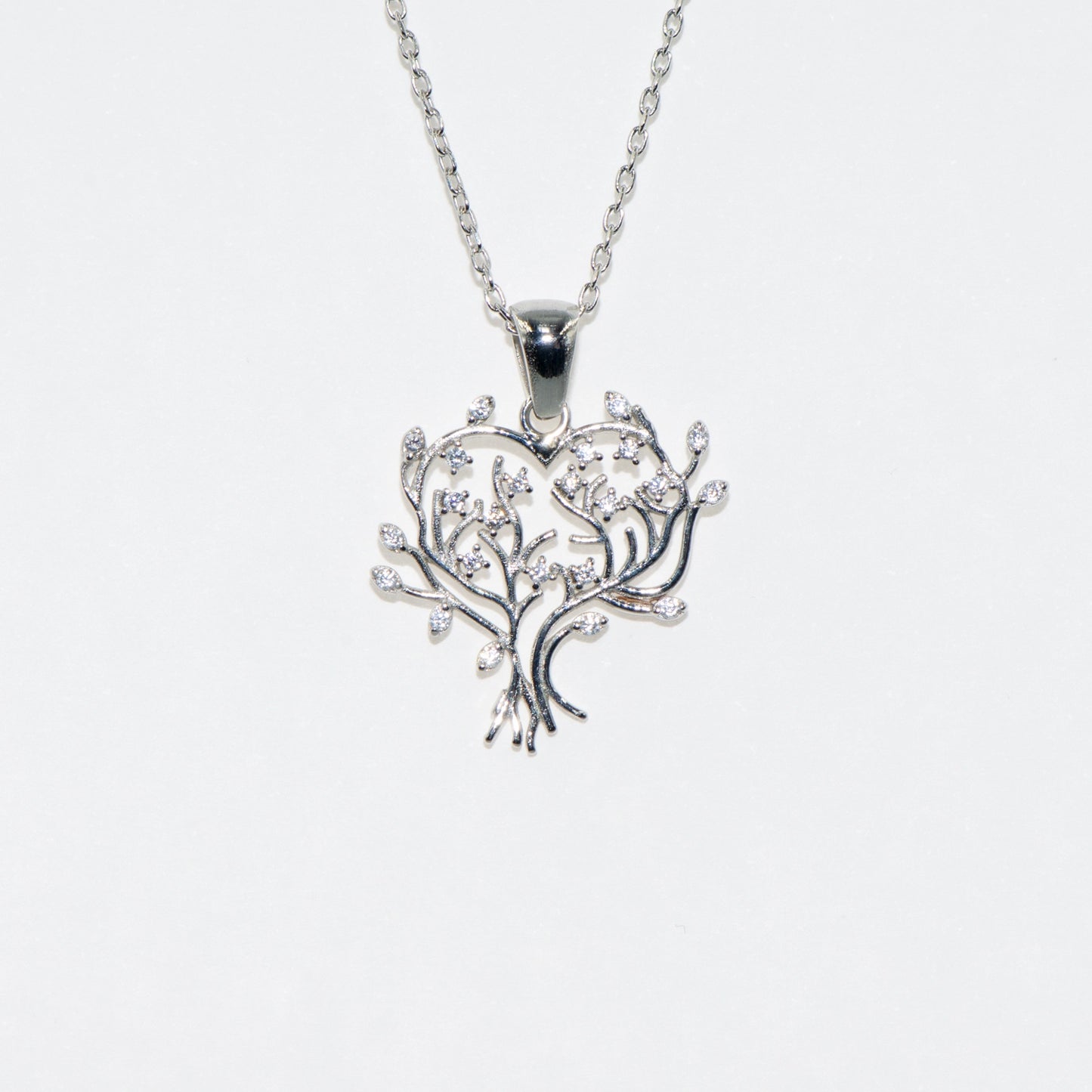 Elegante 925 Silber Halskette mit Lebensbaum Anhänger in Herzform. Verziert mit funkelnden weissen Zirkonia-Steinen und rhodinierter Oberfläche.