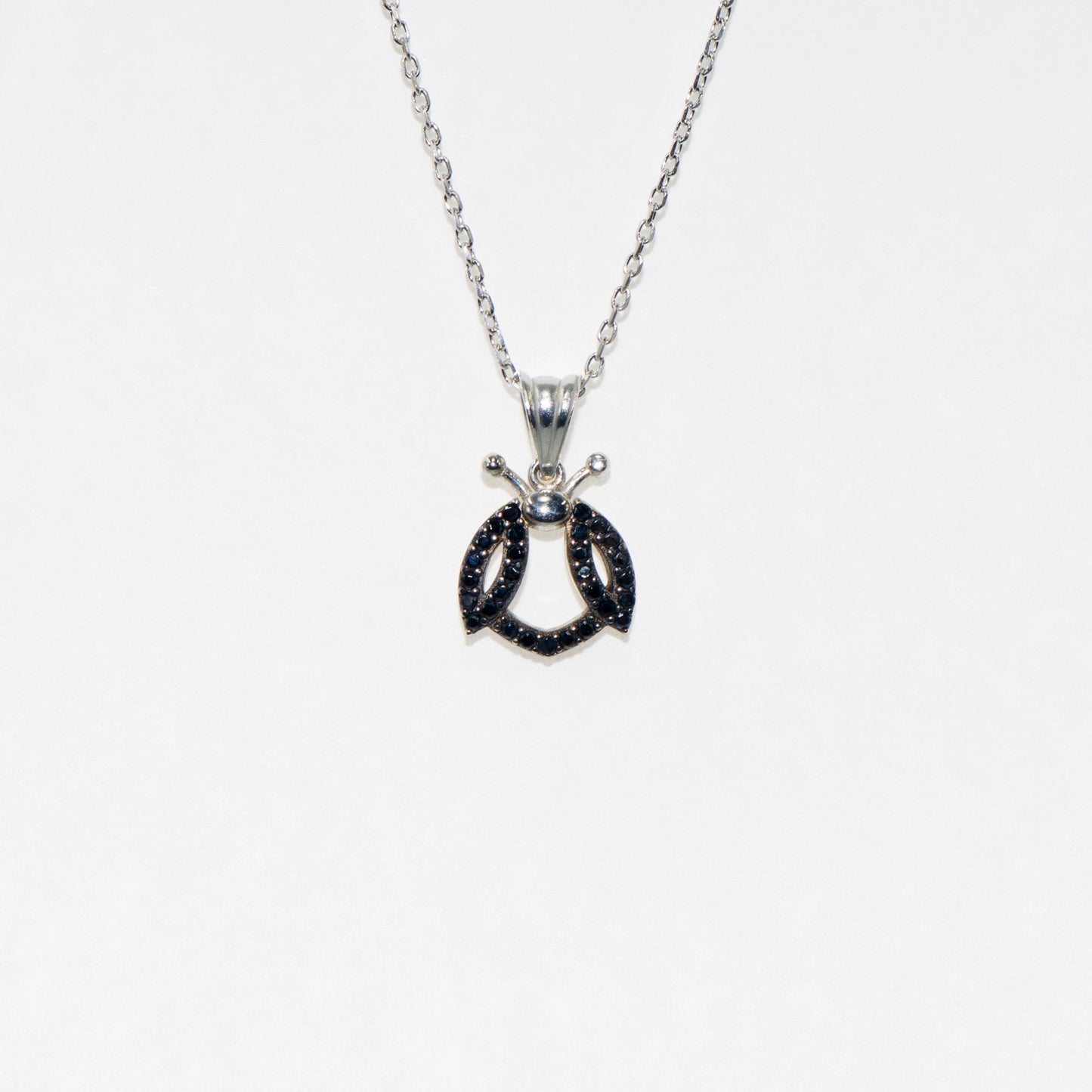 Elegante 925 Silber Halskette mit Marienkäfer Anhänger. Verziert mit schwarzen Zirkonia-Steinen und rhodinierter Oberfläche. Symbol für Glück und Freude.