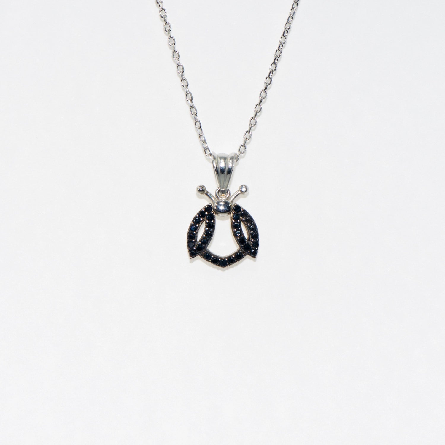 Elegante 925 Silber Halskette mit Marienkäfer Anhänger. Verziert mit schwarzen Zirkonia-Steinen und rhodinierter Oberfläche. Symbol für Glück und Freude.