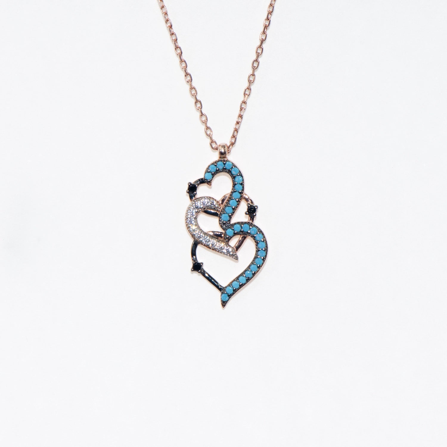 Elegante 925 Silber Halskette mit ineinander verschlungenen rosévergoldeten Herzen. Verziert mit blauen, weissen und schwarzen Zirkonia-Steinen.