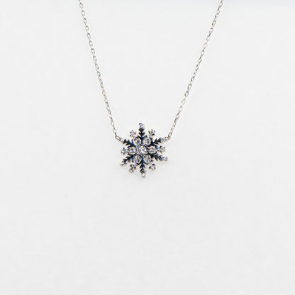 Filigrane 925 Silber Halskette mit Schneeflocken-Anhänger. Verziert mit funkelnden weissen Zirkonia-Steinen und rhodinierter Oberfläche.