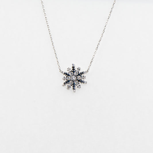 Filigrane 925 Silber Halskette mit Schneeflocken-Anhänger. Verziert mit funkelnden weissen Zirkonia-Steinen und rhodinierter Oberfläche.