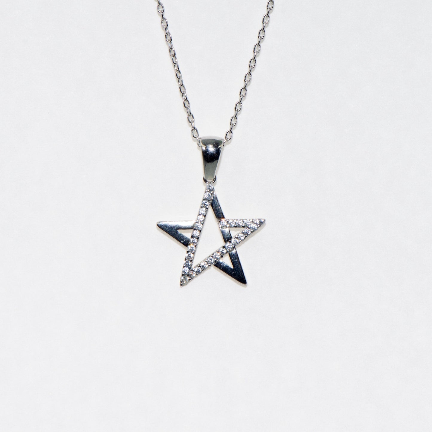 Elegante 925 Silber Halskette mit Stern Anhänger. Verziert mit funkelnden weissen Zirkonia-Steinen und rhodinierter Oberfläche.
