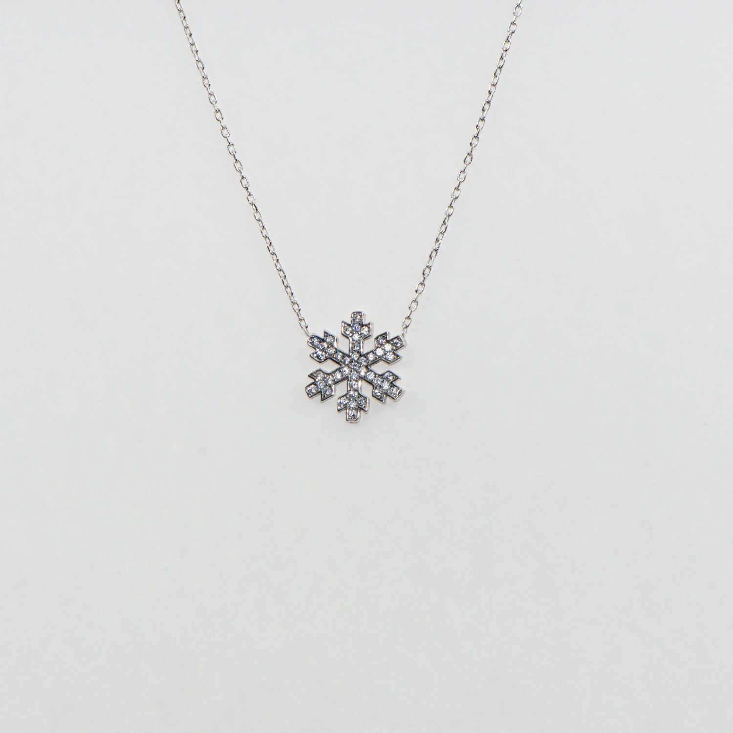 Elegante 925 Silber Halskette mit Stern- und Schneeflocken-Anhänger. Verziert mit funkelnden weissen Zirkonia-Steinen und rhodinierter Oberfläche.