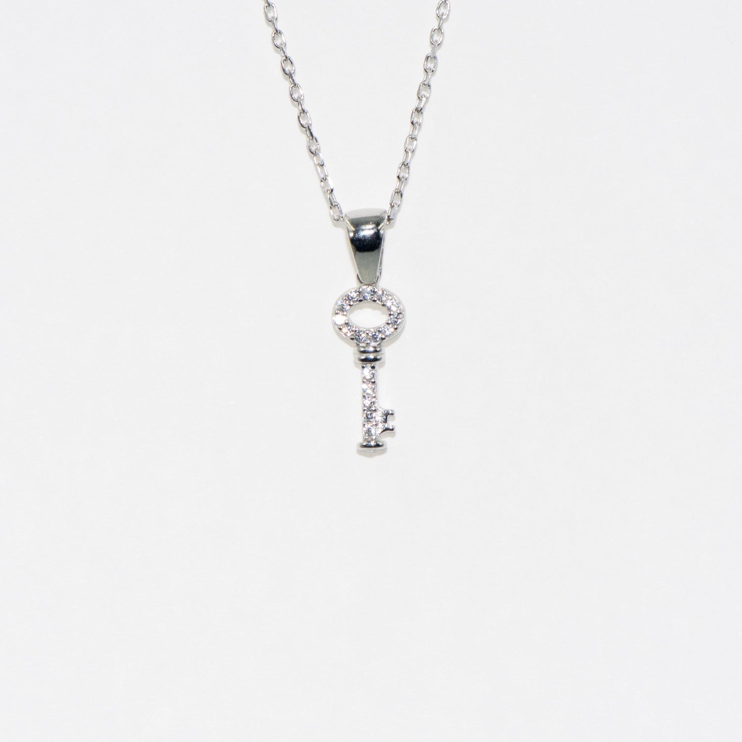 Elegante Halskette mit Anhänger 925 Silber im Symbol Schlüssel Design. Rhodiniert und mit funkelnden Zirkonia-Steinen verziert.