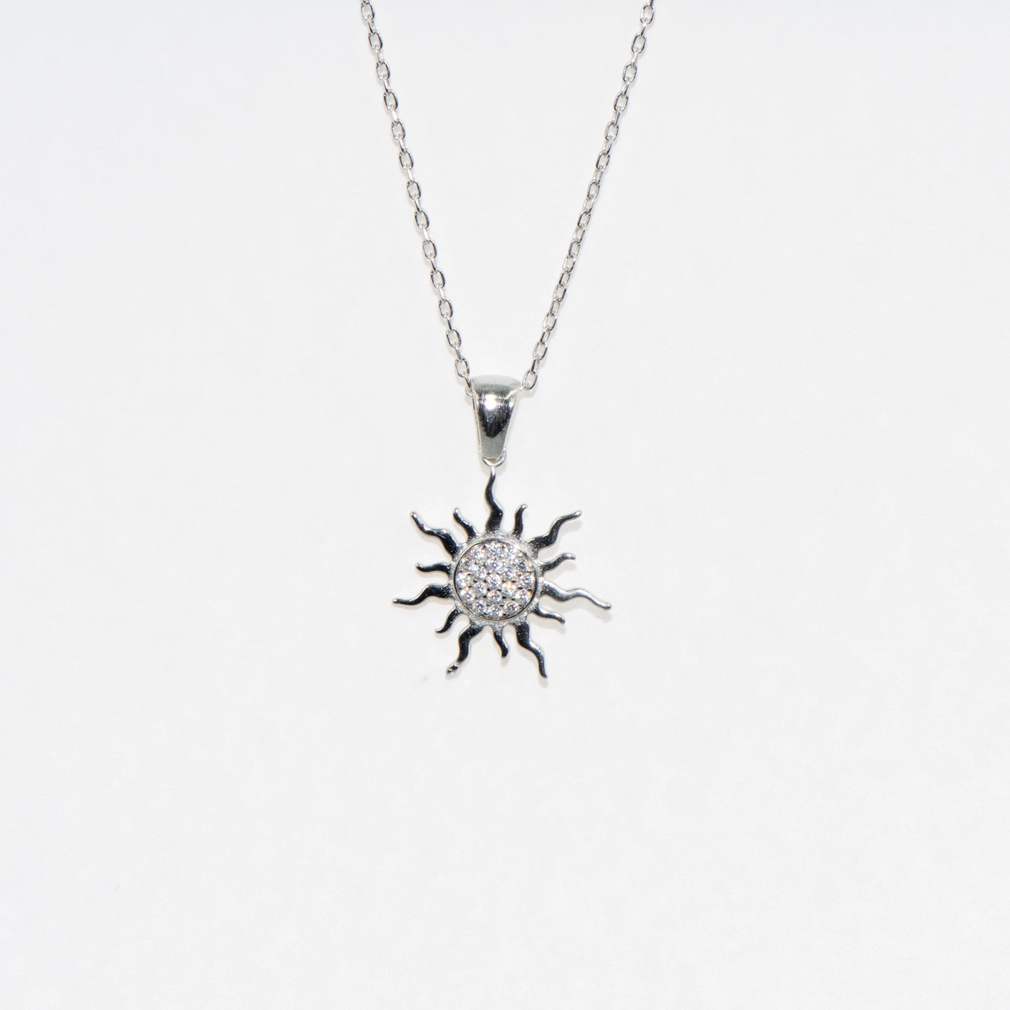 Elegante Halskette mit Sonne Anhänger aus 925 Silber. Rhodiniert und mit funkelnden Zirkonia-Steinen verziert. Zeitloses Schmuckstück mit symbolischer Bedeutung.