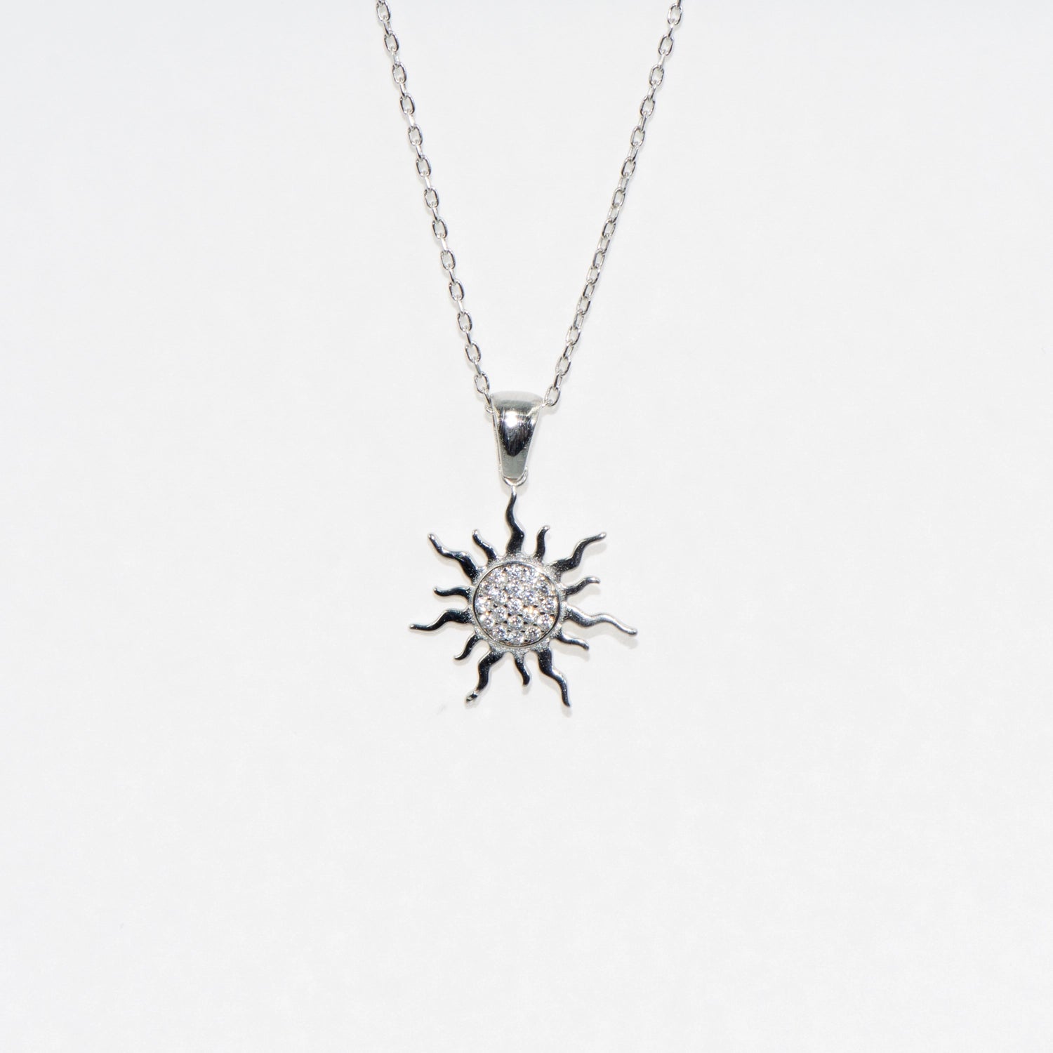 Elegante Halskette mit Sonne Anhänger aus 925 Silber. Rhodiniert und mit funkelnden Zirkonia-Steinen verziert. Zeitloses Schmuckstück mit symbolischer Bedeutung.