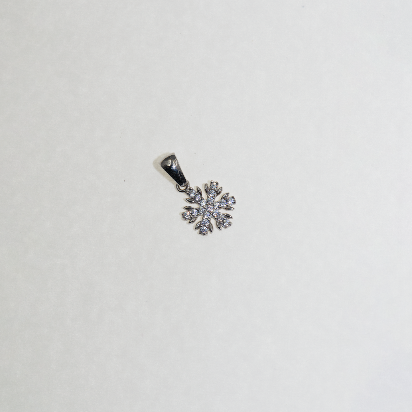 Kleiner Schneeflocke Anhänger aus Silber 925 mit funkelnden Zirkonia-Steinen und feinem winterlichem Design.