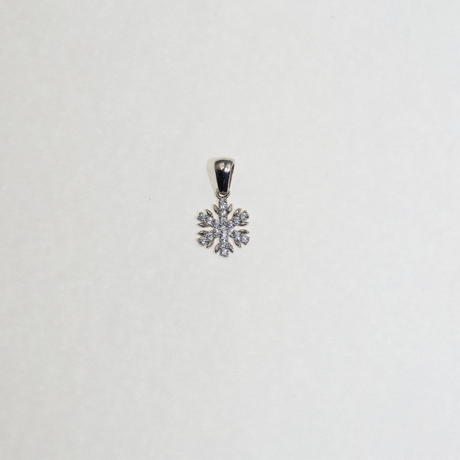 Kleiner Schneeflocke Anhänger aus Silber 925 mit funkelnden Zirkonia-Steinen und feinem winterlichem Design.
