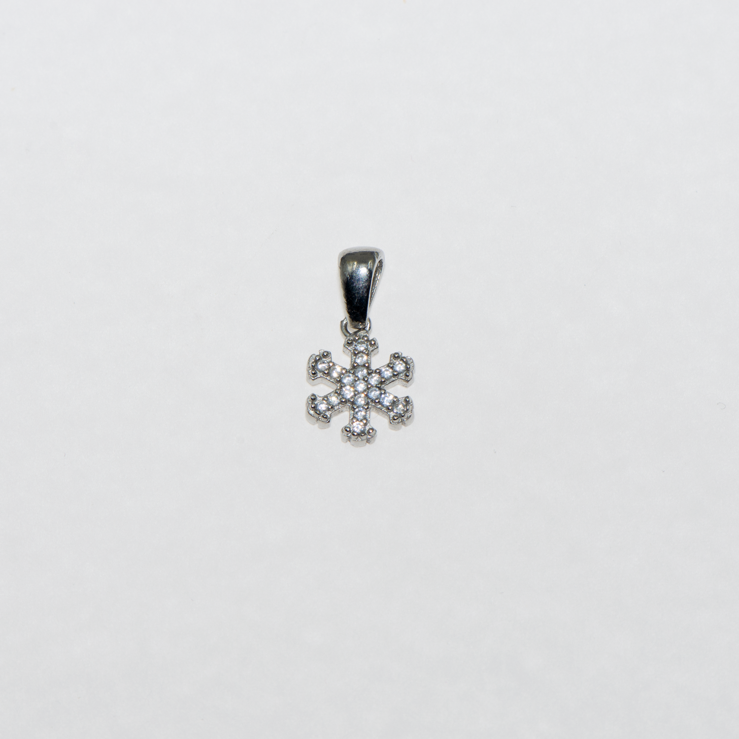 Kleiner Schneeflocke Anhänger aus Silber 925 mit weissen Zirkonia und rhodinierter Oberfläche.