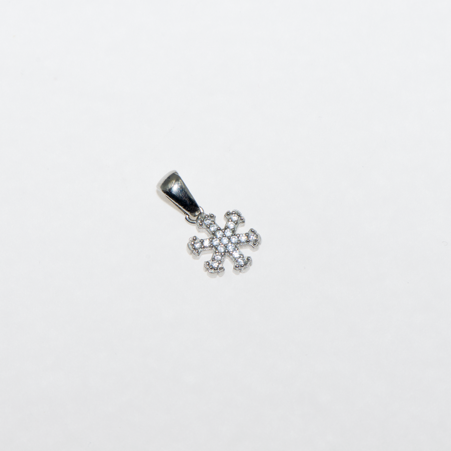 Kleiner Schneeflocke Anhänger aus Silber 925 mit weissen Zirkonia und rhodinierter Oberfläche.