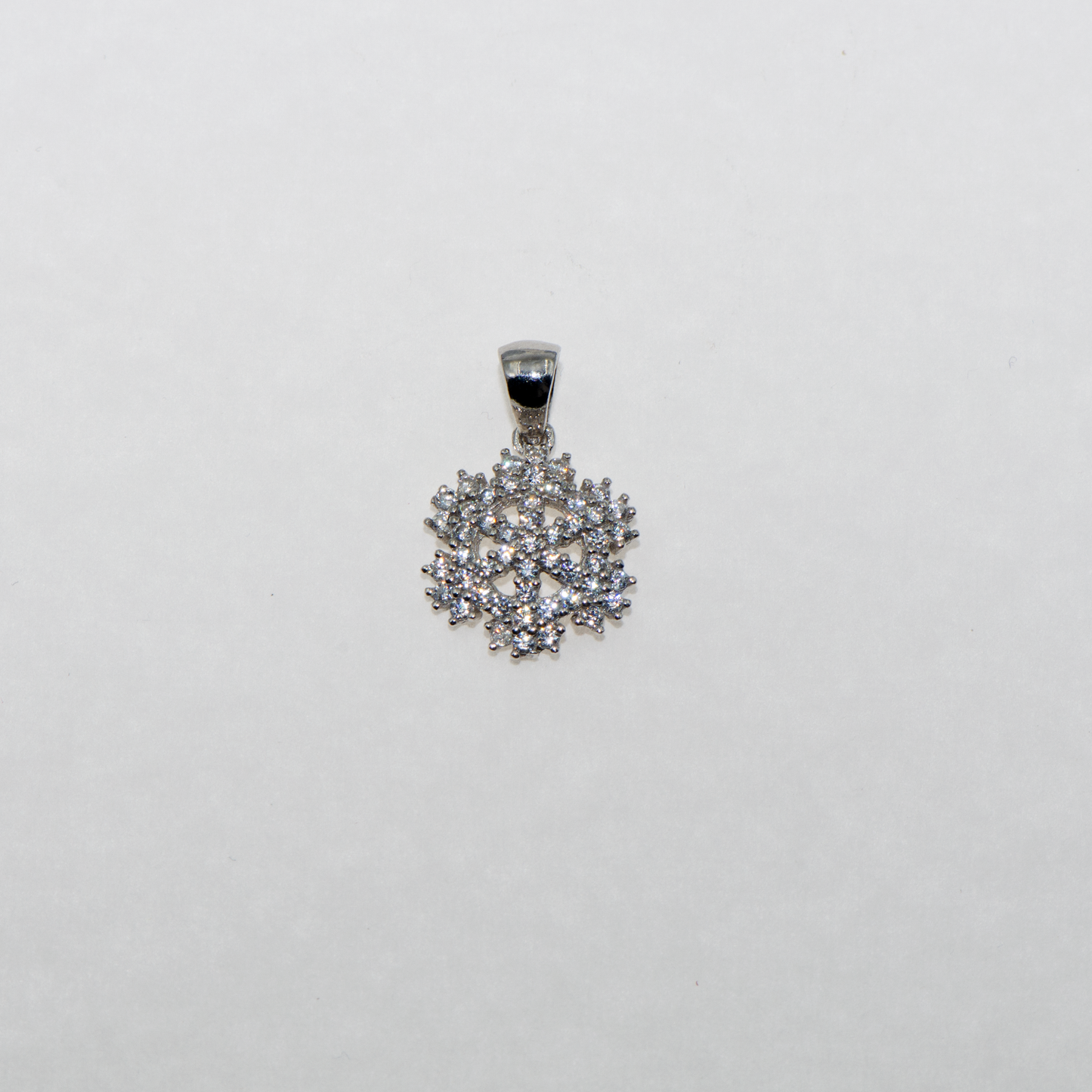 Kleiner Schneeflocke Anhänger aus Silber 925 mit weissen Zirkonia und rhodinierter Oberfläche im modernen Design