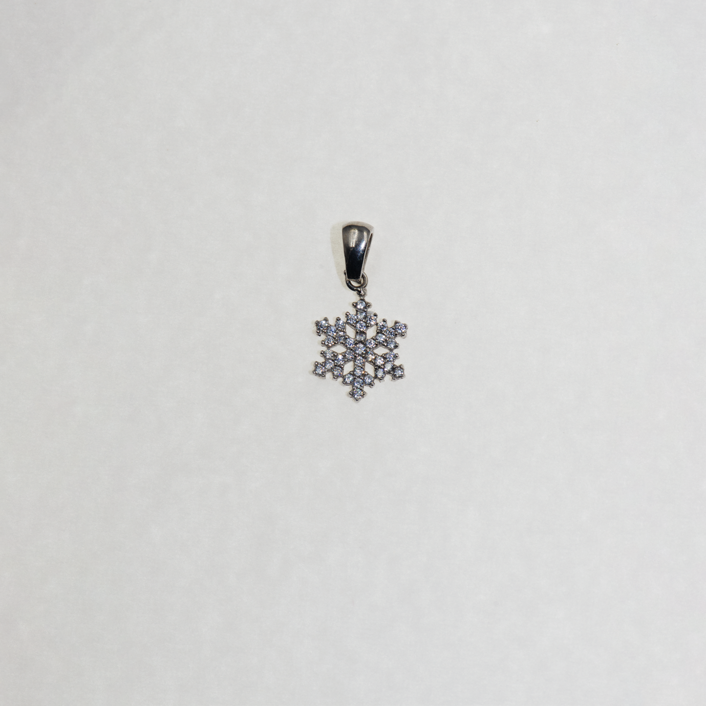 Kleiner Silber Schneeflocke Anhänger mit funkelnden Zirkonia-Steinen und elegantem winterlichem Design.