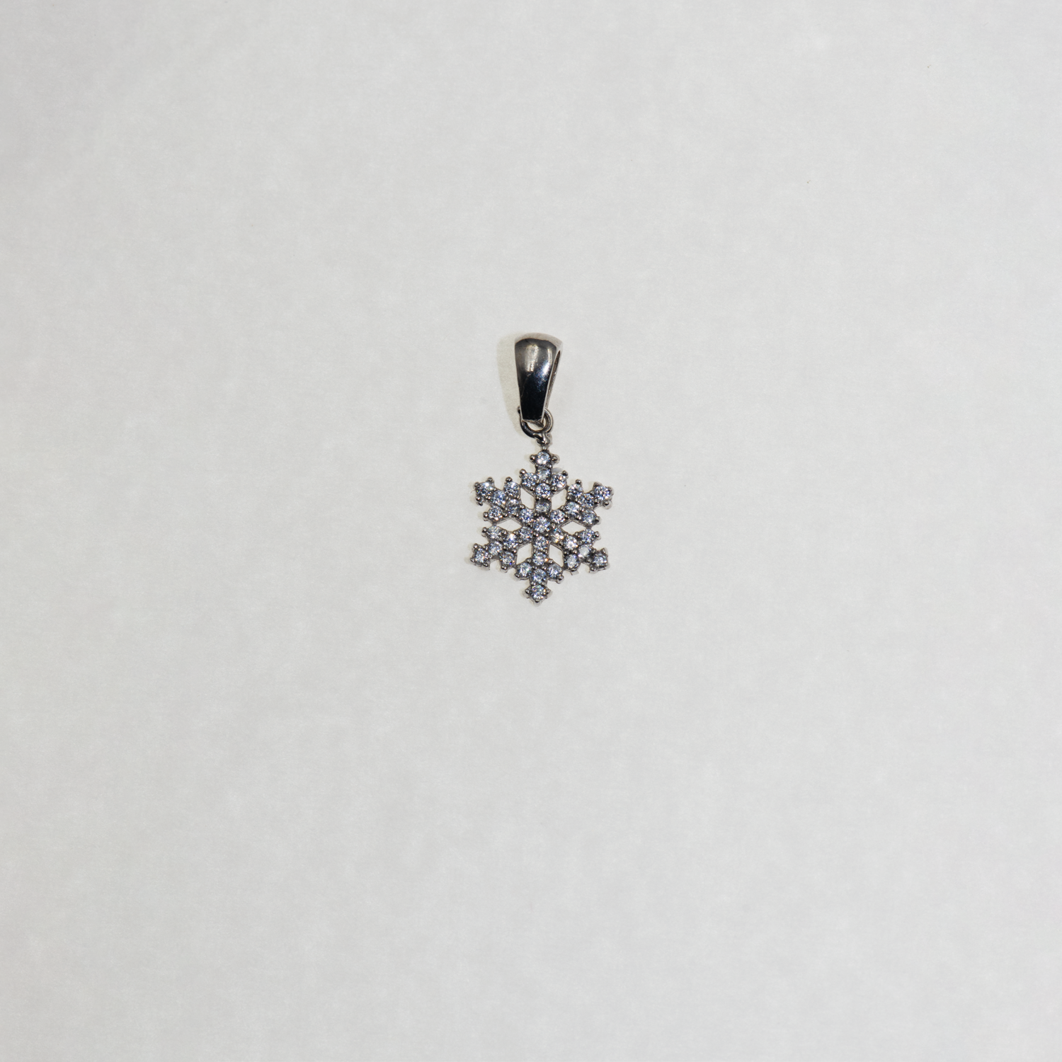 Kleiner Silber Schneeflocke Anhänger mit funkelnden Zirkonia-Steinen und elegantem winterlichem Design.