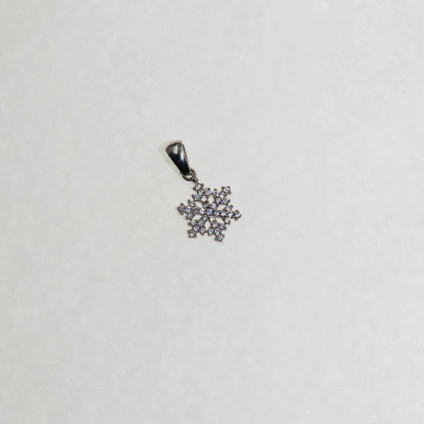Kleiner Silber Schneeflocke Anhänger mit funkelnden Zirkonia-Steinen und elegantem winterlichem Design.