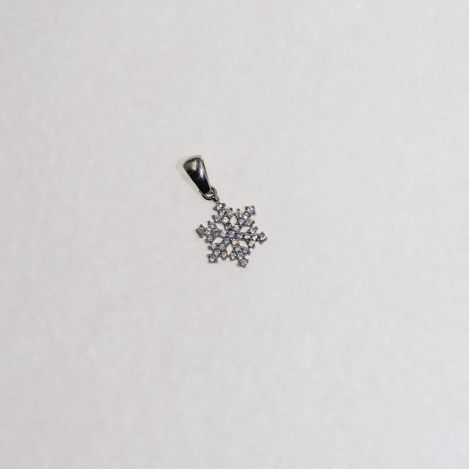Kleiner Silber Schneeflocke Anhänger mit funkelnden Zirkonia-Steinen und elegantem winterlichem Design.