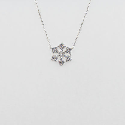 Moderne Schneeflocke Halskette aus 925 Silber mit funkelnden weissen Zirkonia-Steinen und rhodinierter Oberfläche.