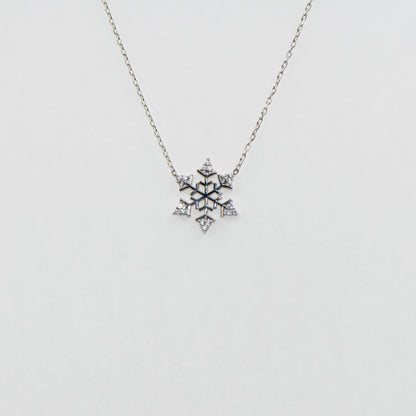 Filigrane Schneeflocke Halskette mit Anhänger CH aus 925 Silber. Verziert mit funkelnden weissen Zirkonia-Steinen und rhodinierter Oberfläche.